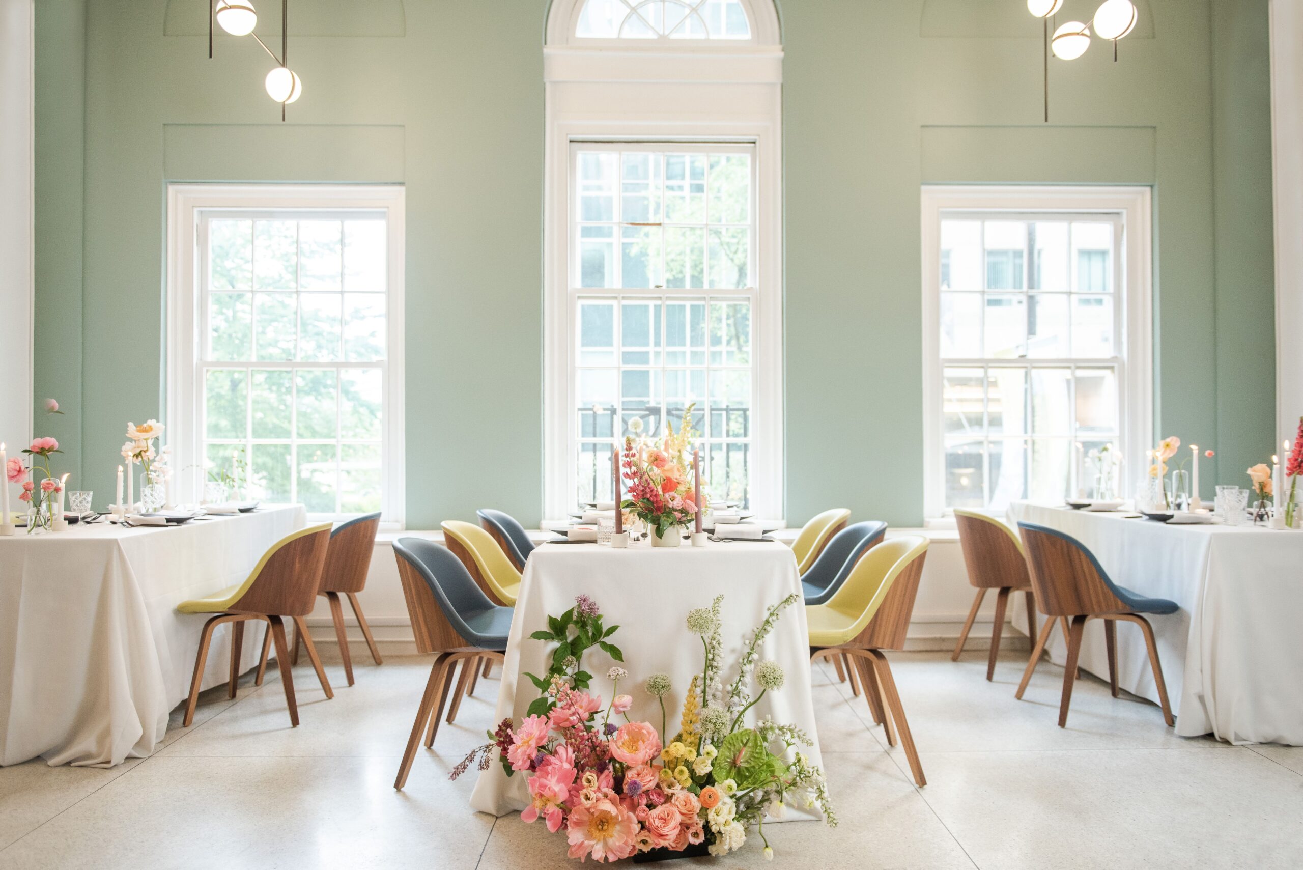 Colourful wedding reception with bright chairs and colourful flowers