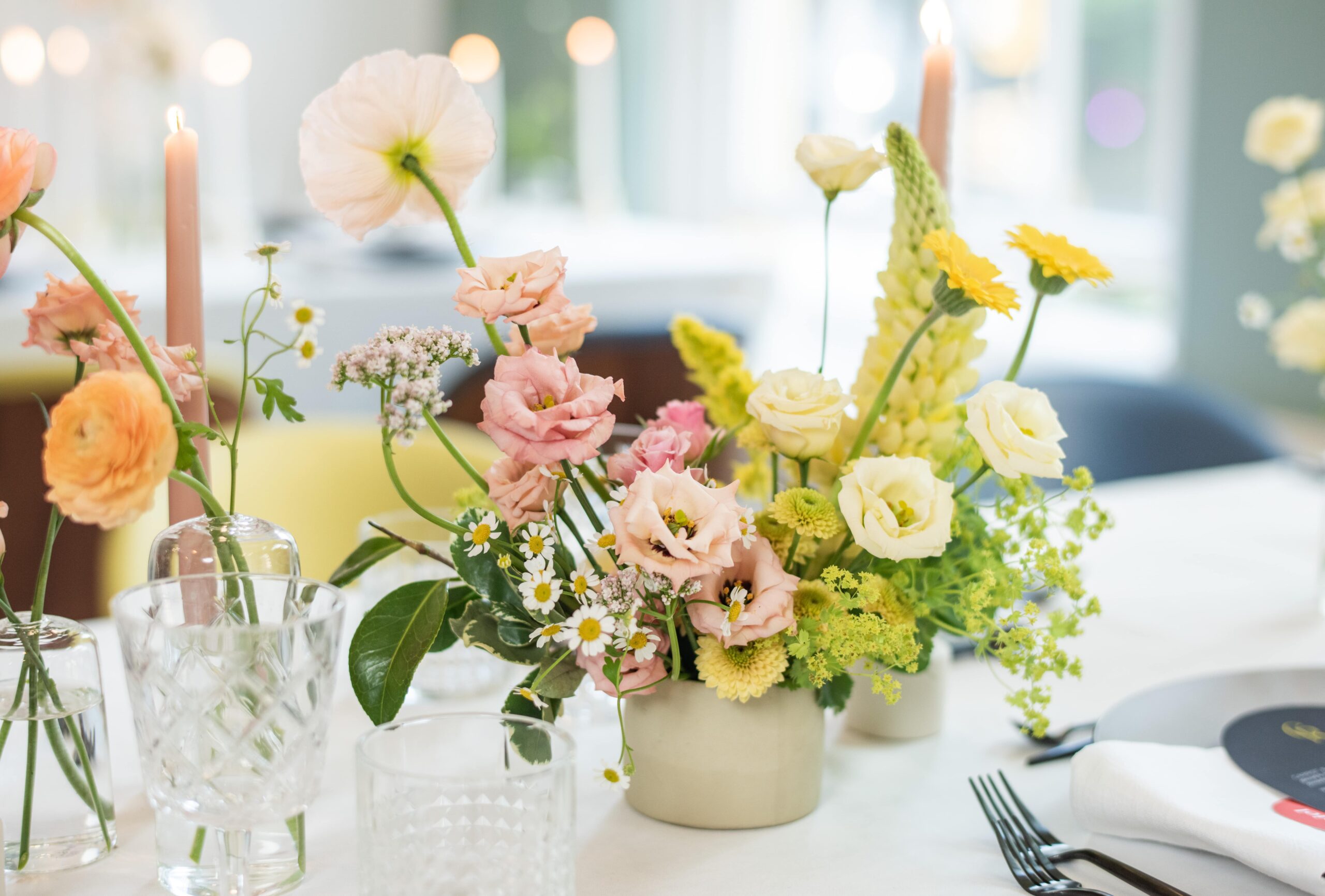 Pink and yellow floral centrepiece at modern wedding table