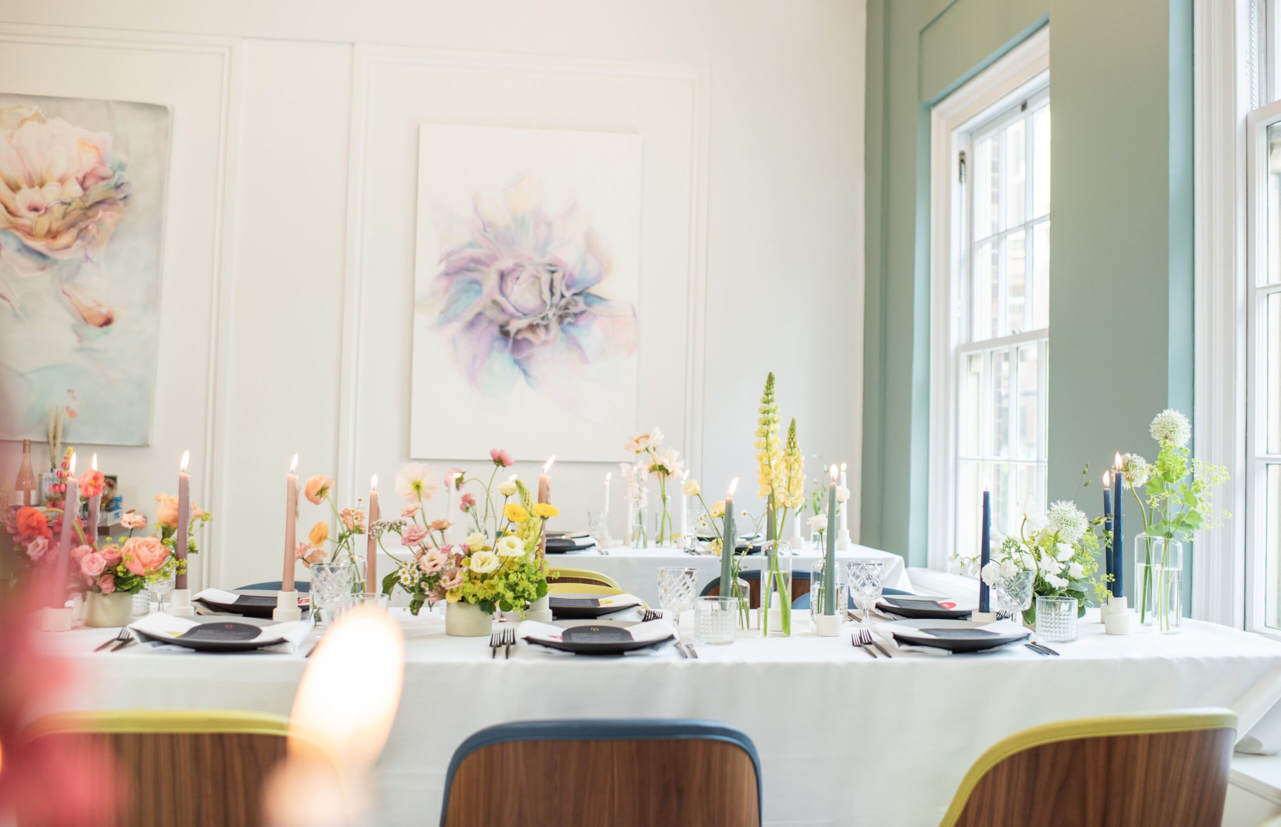 Colourful floral arrangements and colourful candles at modern wedding