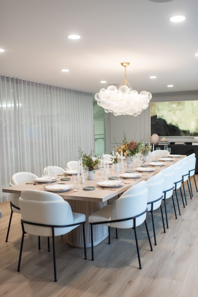 Long table with white chairs in the White Table Catering tasting lounge